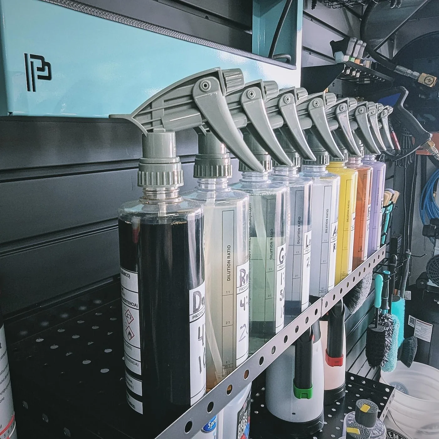 Labeled spray bottles arranged on the studio wall